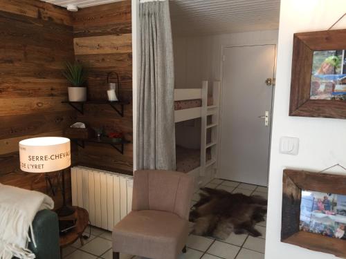 - une chambre avec une chaise, un lit et un berceau dans l'établissement Serre Chevalier Chantemerle T2 + coin montagne en RDC pour 6 personnes, à Saint-Chaffrey