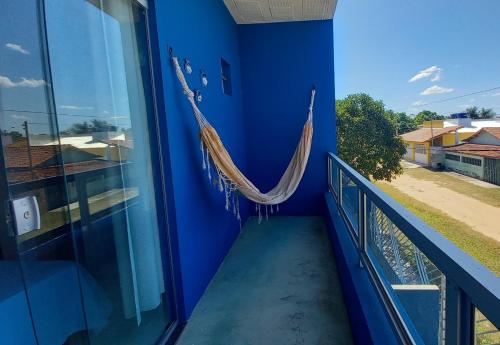 a blue room with a hammock on a balcony at Residencial Praia Quente casas in Nova Viçosa