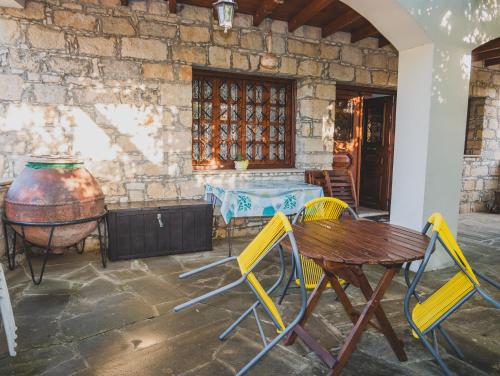 a patio with a table and chairs and a barrel at Revecca House in Ayios Mamas