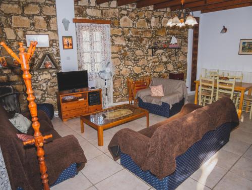 a living room filled with furniture and a stone wall at Revecca House in Ayios Mamas