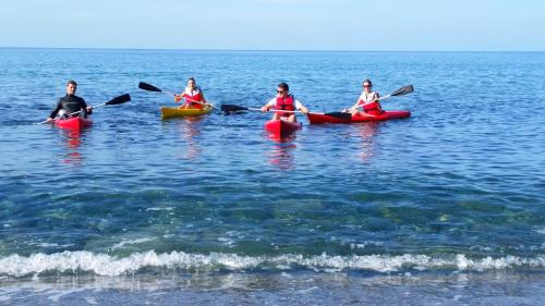 three people in kayaks in the water on the water at Astrofegia Apartments Near The Sea in Ayia Marina