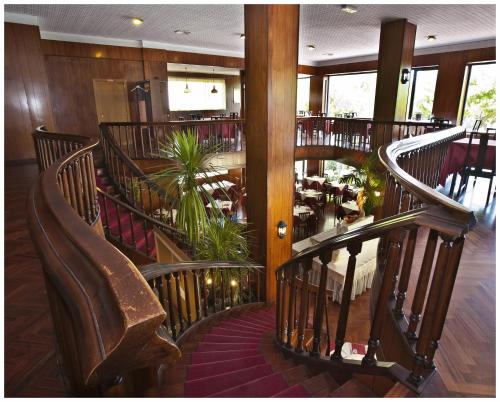 a restaurant with a spiral staircase with chairs and tables at Hotel La Perla Preziosa in Grottammare