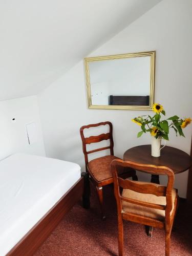 a bedroom with a bed and a table and chairs at Pokoje nad Młynem in Stryków
