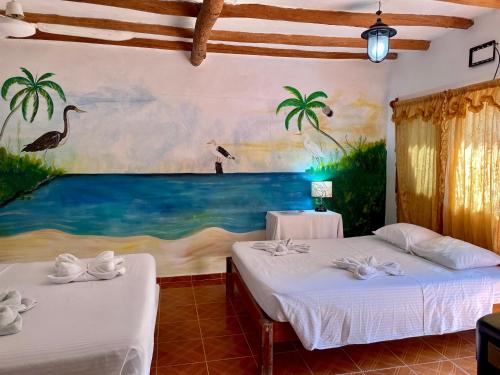 two beds in a room with a painting on the wall at Hotel and Beach Club Escape Holbox in Holbox Island