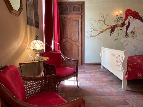 a room with chairs and a bed and a table at Chambres d'Hotes Raviere in Bouhy