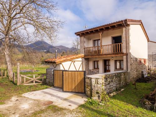 una casa con una puerta de madera y una valla en Casa Rural Picu Llagos, en Cangas de Onís