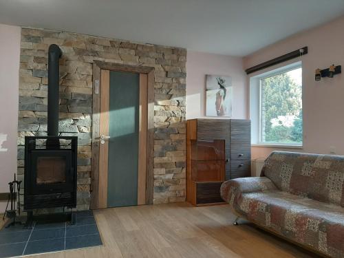 a living room with a stone fireplace and a couch at AVIATRIX Night Airport Haven in Rīga