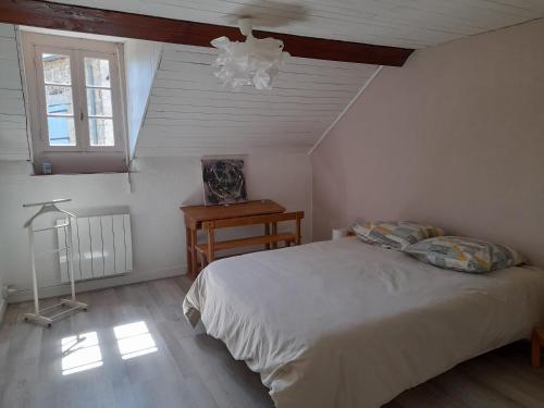 a bedroom with a white bed and a window at Gîte du bois blanc in Saint-Clément