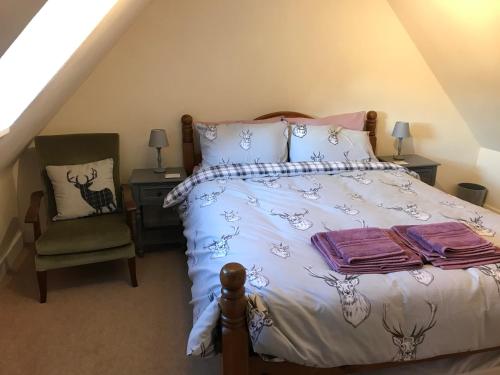 une chambre avec un lit et une chaise dans l'établissement Kildinguie - Traditional Cottage - on NC 500 Route, à Tongue