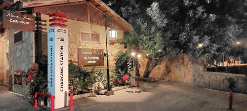 a sign in front of a building at night at Kemerli Konak Boutique Hotel in Kérynia