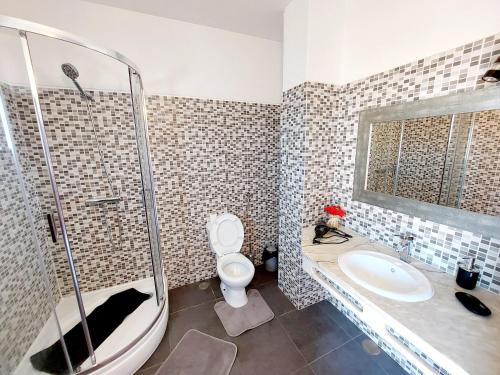 a bathroom with a shower and a sink and a toilet at Sol Brilhante in Albufeira