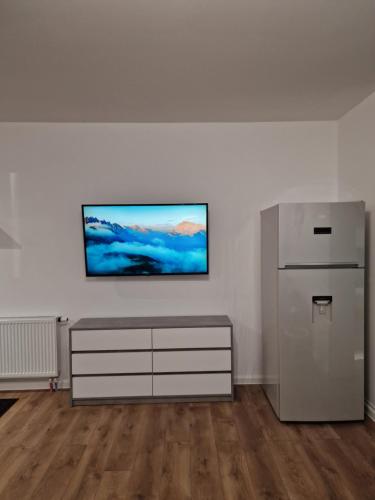 a white room with a dresser and a television on a wall at Vic Apartament in Drobeta-Turnu Severin