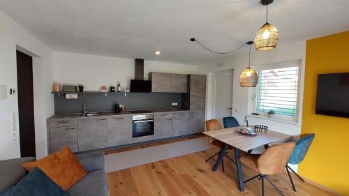 eine Küche mit einem Tisch und einem Esszimmer in der Unterkunft T-Collection Premium Apartments in Sterzing