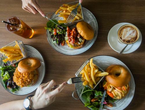 a table with four plates of food on it at Studio M Hotel in Singapore