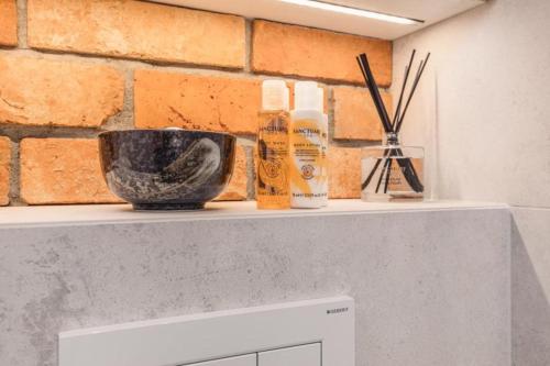 a shelf with bottles and a bowl on top of a microwave at Modern Riverside Apartment with Free parking space in Szczecin