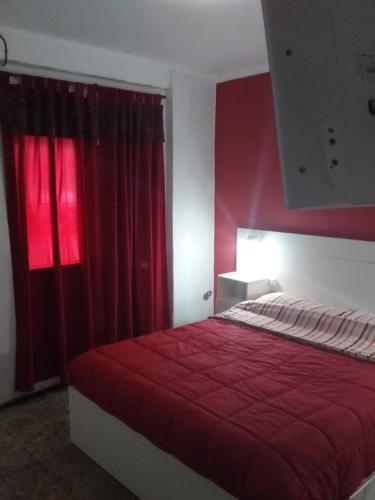 een slaapkamer met een rood bed en een rood raam bij dpto centrico in Santa Fe
