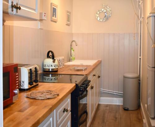a kitchen with a sink and a stove top oven at Creran Apartment, Kinlochlaich House in Appin