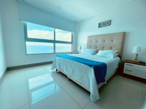 a bedroom with a bed and a large window at Apartamento Frenta a la Playa in Cartagena de Indias