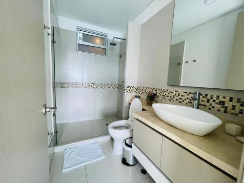 a bathroom with a sink and a toilet and a mirror at Apartamento Frenta a la Playa in Cartagena de Indias