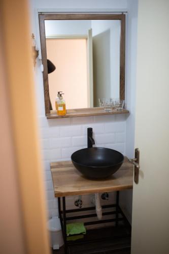 a bathroom with a black sink and a mirror at Apartments & Room - Korzo in Sombor