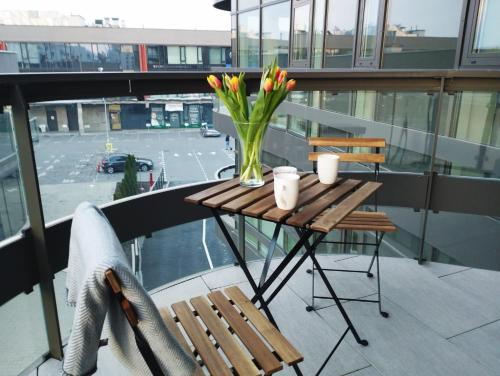 a table with a vase of flowers on a balcony at Sleep in Plaza in Kielce