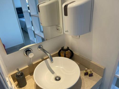 un bagno con un lavandino bianco e uno specchio di Super Confort Santa Marta a Gaira