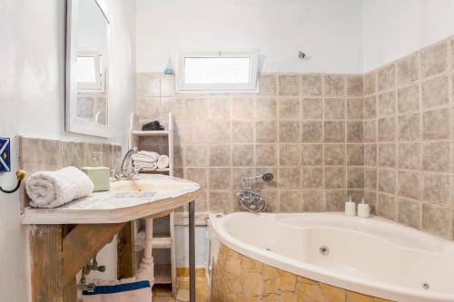 a bathroom with a tub and a sink at Si-Har Chalets in Nimrod