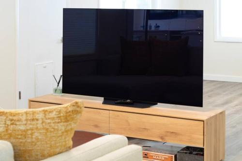 a flat screen tv sitting on a wooden stand in a living room at Waterfront Cabin at White Pass and Mount Rainier National Park in Packwood