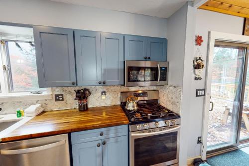 a kitchen with blue cabinets and a stove top oven at Ludlow Comfy Cabin in Ludlow