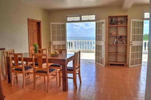 uma sala de jantar com uma mesa e vista para o oceano em Oceanfront 3-bedroom villa with spectacular view! em Calibishie