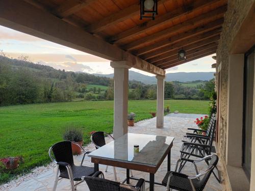 einen Tisch und Stühle auf einer Terrasse mit Blick auf ein Feld in der Unterkunft Casa Os Prados da Albela in Tríacastela