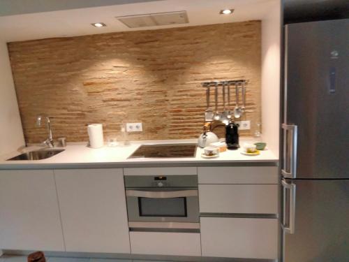 a kitchen with a stove and a refrigerator at Onyar apartments Rambla de la llibertat 27 in Girona