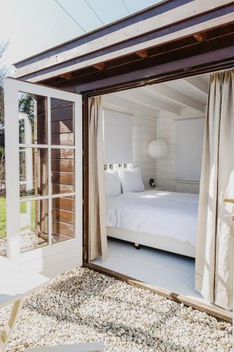 a bedroom with a bed and a large window at HOLLAND Holiday Home in Ermelo