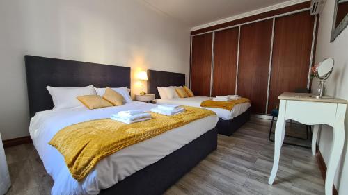 1 dormitorio con 2 camas, mesa y escritorio en Santa Luzia Apt I en Ribeira Grande