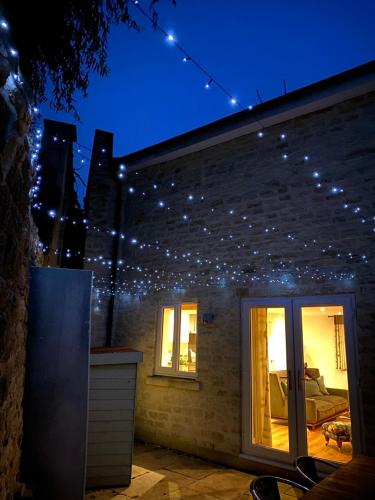 a house with christmas lights on the side of it at Burgess Yard 2-bedroom cottage, Bath in Bath