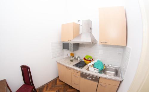 a small kitchen with a sink and a microwave at Apartments & Room - Korzo in Sombor