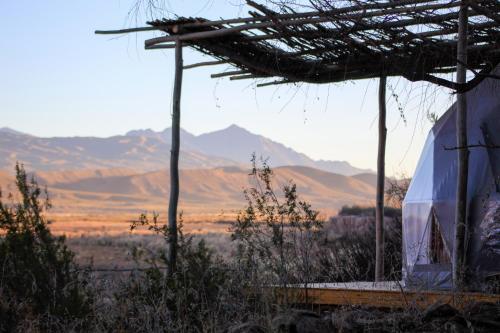 a building with a roof with mountains in the background at Domos Uspallata in Uspallata