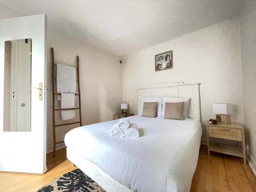 a bedroom with a large white bed with towels on it at LE ROI SOLEIL • 4min Château Versailles • 1min Gare Versailles Rive Gauche in Versailles