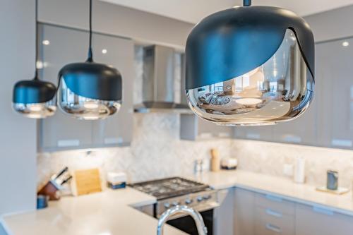 a kitchen with blue cabinets and a large mirror at Amazing 3 Bed 4 Bath Penthouse with Roof Top Terrace close to Airport in Mississauga