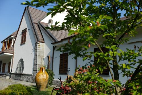 a white house with a vase in front of it at Blu Lavanda Bed & Breakfast in Luserna San Giovanni