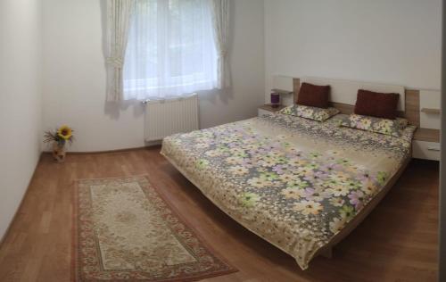 a bedroom with a large bed in a room with a rug at Cosy apartment I in Târgu-Mureş