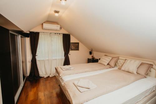 1 dormitorio con 2 camas frente a una ventana en Forest House en Palić