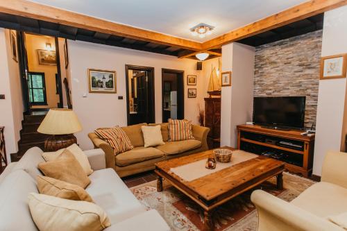 a living room with a couch and a tv at Forest House in Palić