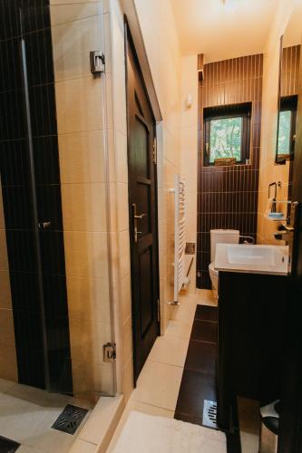 a bathroom with a sink and a toilet and a door at Forest House in Palić
