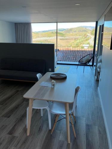 a table and chairs in a living room with a view at DouroXisto in Peso da Régua