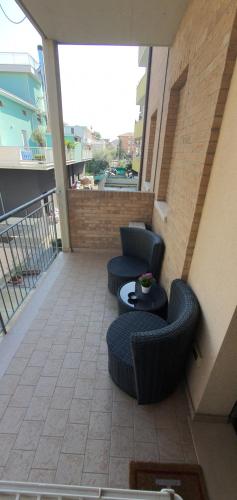 基亞拉瓦萊的住宿－Sweet Home，大楼内的阳台配有两把椅子和一张桌子
