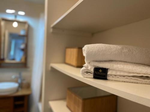 a bathroom with white towels on a shelf at LE ROI SOLEIL • 4min Château Versailles • 1min Gare Versailles Rive Gauche in Versailles
