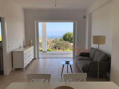 a living room with a couch and a table with a view at Villa Peony Koroni in Koroni