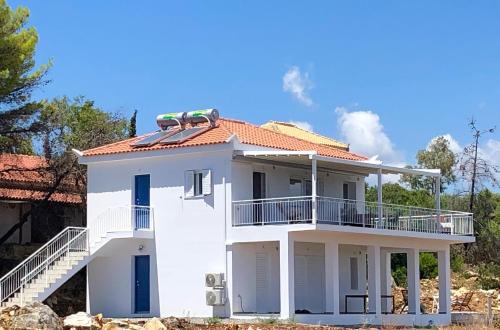 a white house with a balcony on top of it at Villa Peony Koroni in Koroni