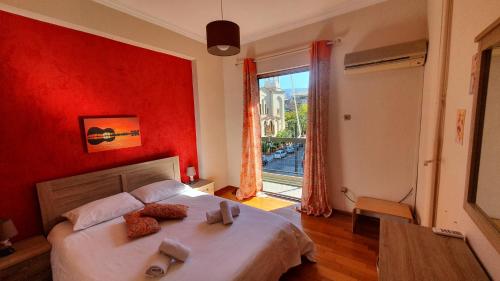 - une chambre avec un lit aux murs rouges et une fenêtre dans l'établissement Marianas Inn, à Athènes